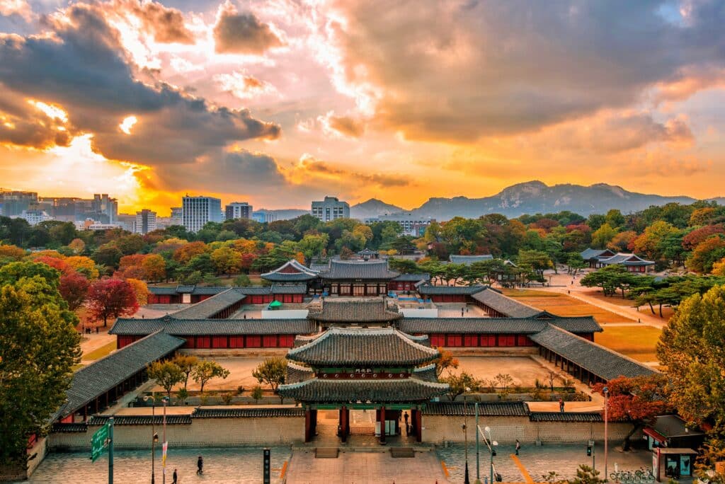 Vue aérienne du palais Changdeokgung à Séoul, illuminé par les teintes chaudes du coucher de soleil.