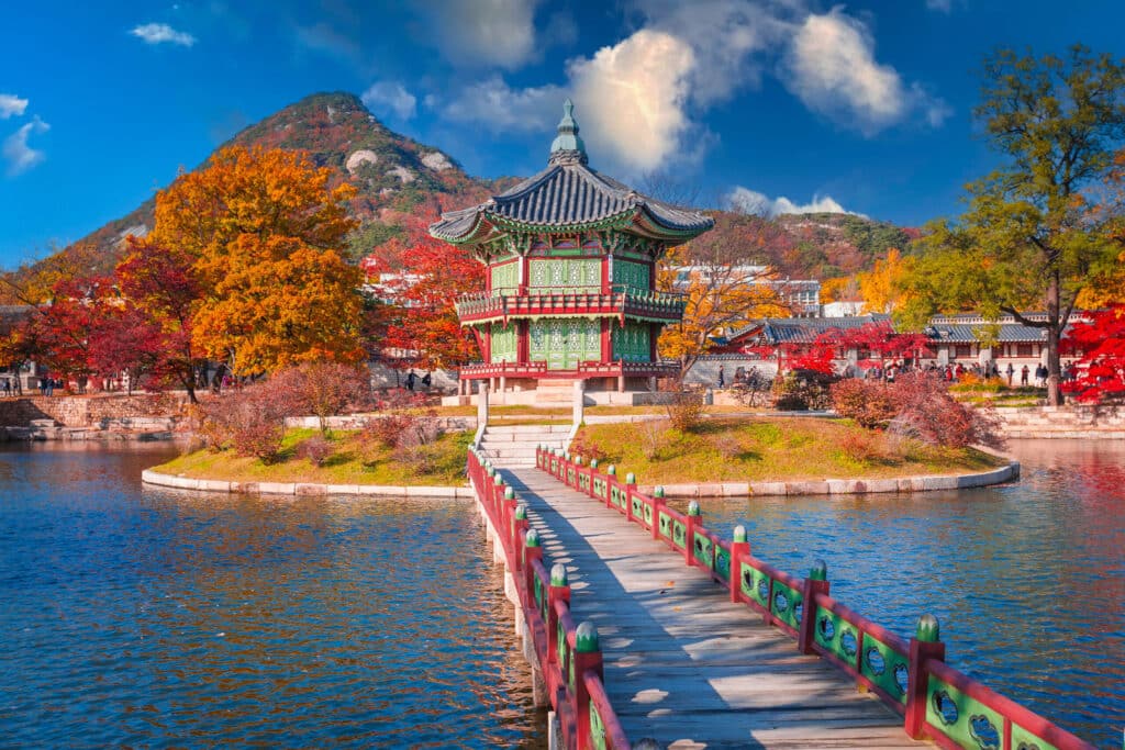 Pavillon Hyangwonjeong au cœur du palais Gyeongbokgung à Séoul, entouré d’arbres aux couleurs automnale