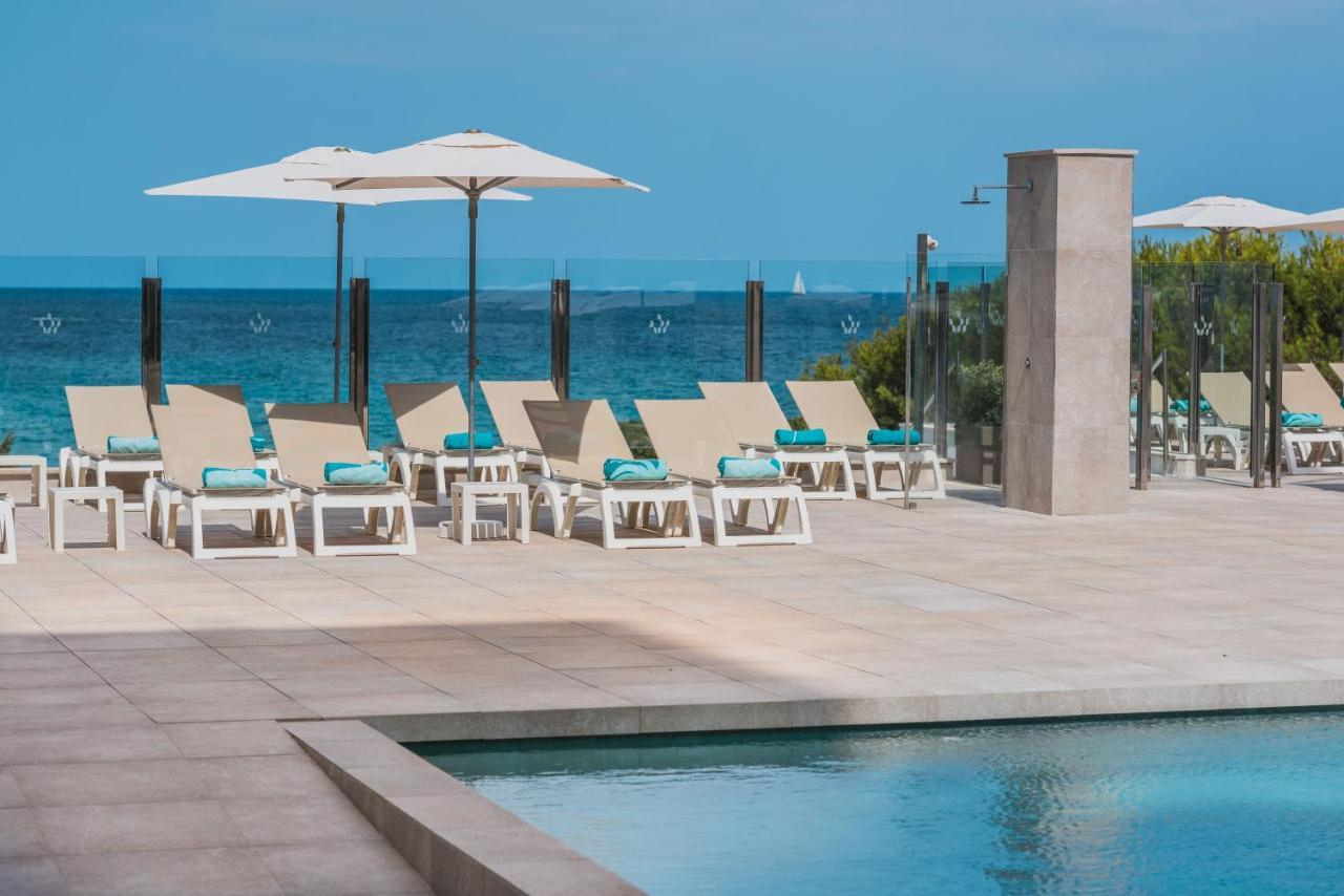 http://Chaises%20longues%20sur%20la%20terrasse%20de%20la%20piscine%20avec%20parasols%20et%20vue%20sur%20la%20mer%20à%20l'Iberostar%20Cala%20Millor
