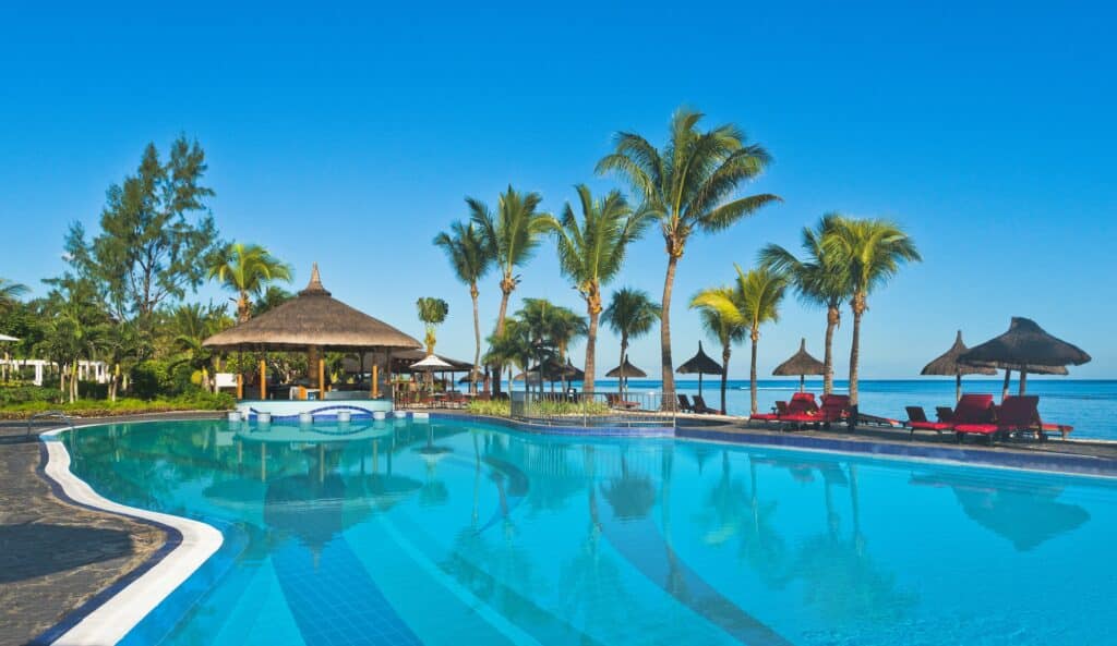 Grande piscine d’hôtel avec transats et palmiers à l’île Maurice