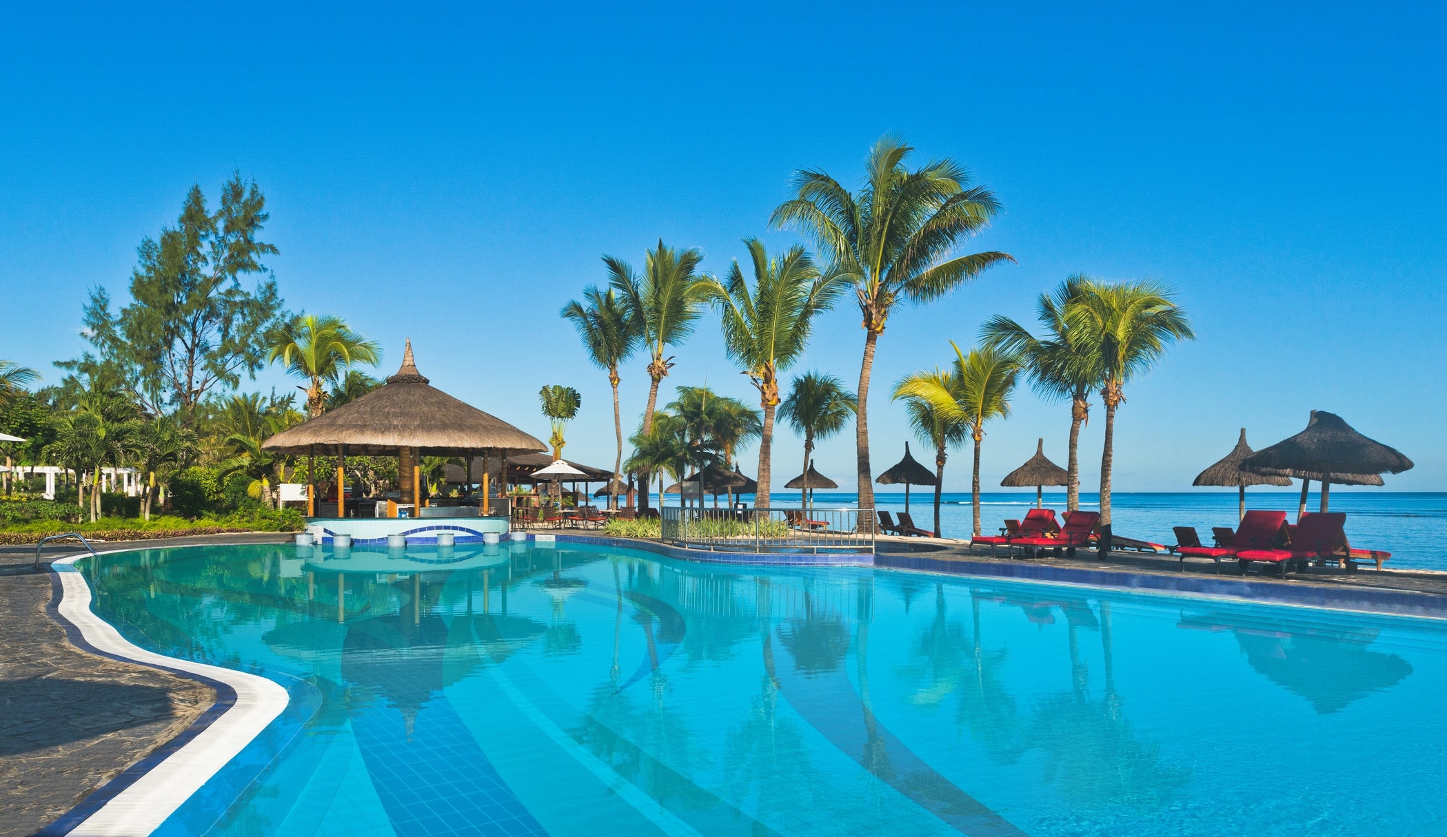 http://Grande%20piscine%20d’hôtel%20avec%20transats%20et%20palmiers%20à%20l’île%20Maurice