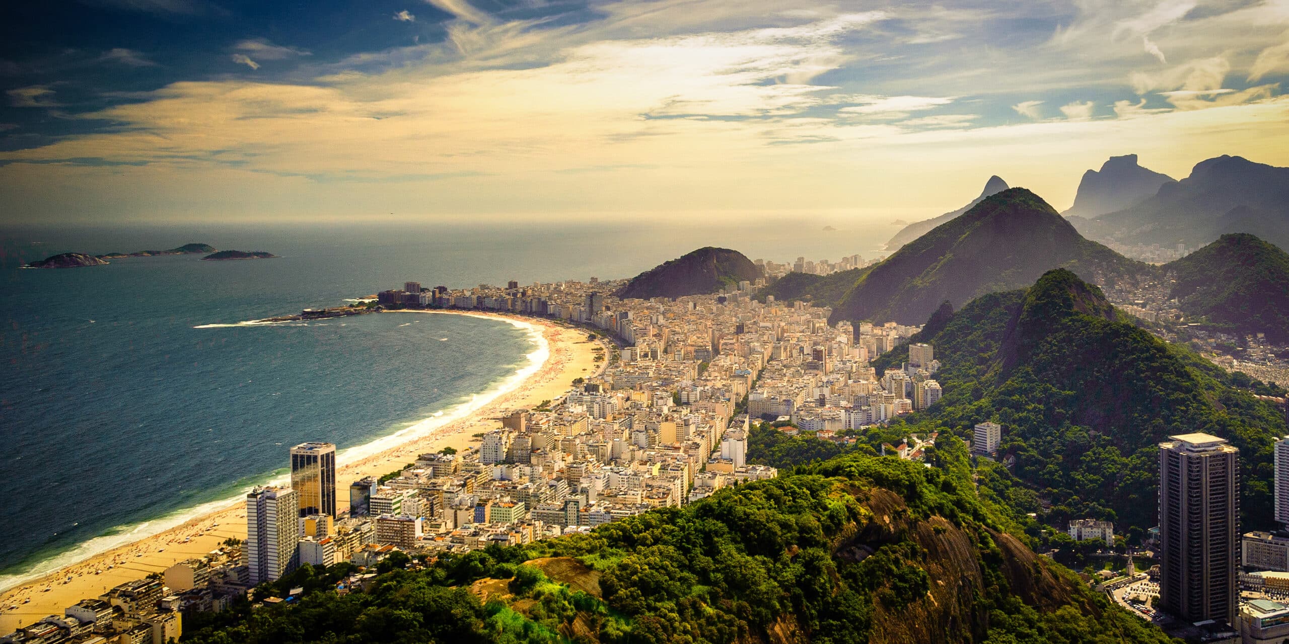 La plage de Copacabana à Rio de Janeiro avec ses immeubles en front de mer et ses eaux bleu-vert.
