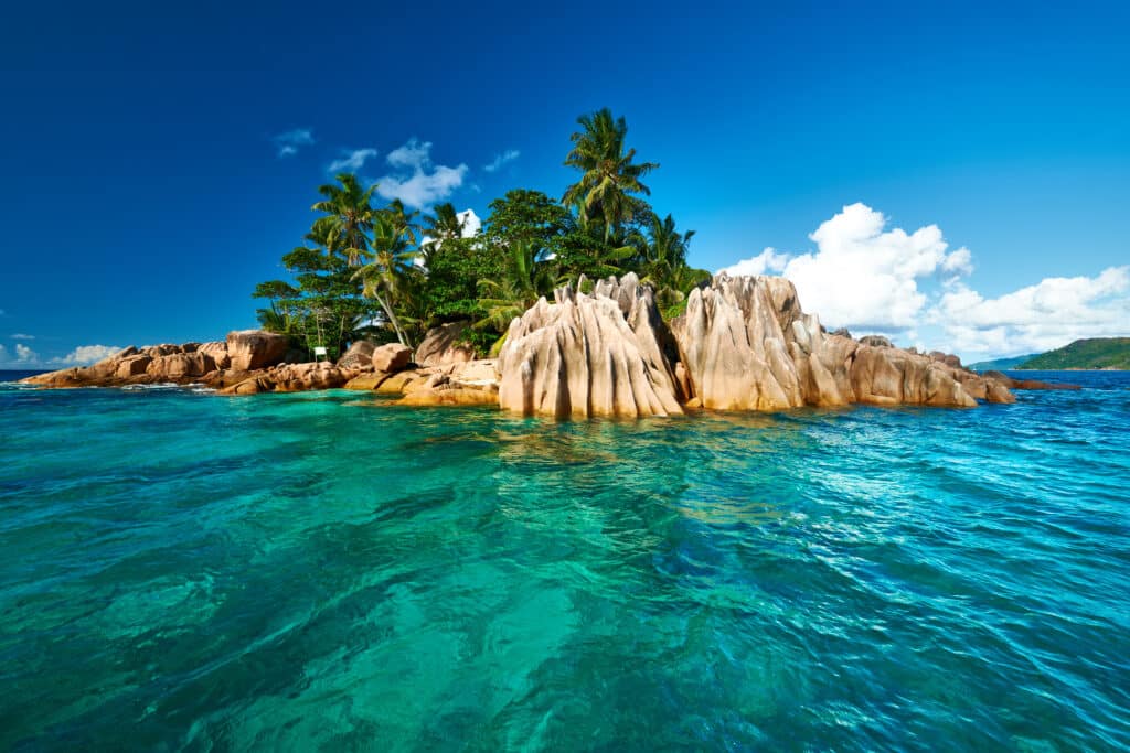 Petite île aux rochers granitiques entourée d’eau turquoise aux Seychelles