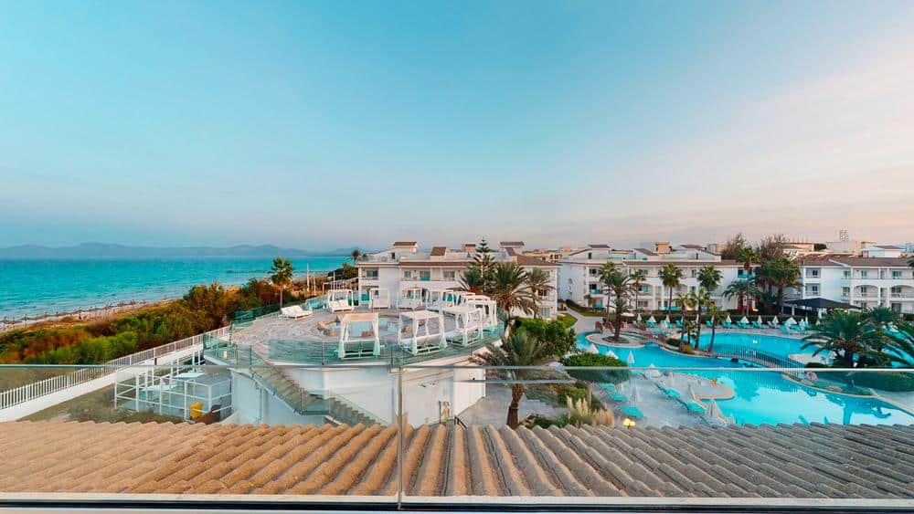 http://Vue%20depuis%20une%20terrasse%20sur%20le%20complexe%20hôtelier,%20avec%20piscine,%20cabanes%20blanches%20et%20mer%20à%20l’horizon.