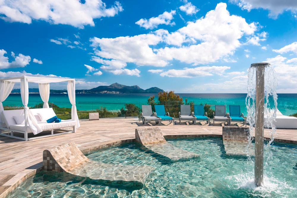 http://Bain%20à%20remous%20extérieur%20avec%20jets%20d’eau%20et%20lits%20balinais%20face%20à%20la%20mer%20turquoise.