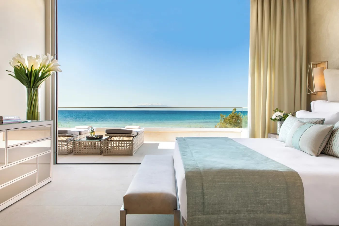 http://Chambre%20d'hôtel%20de%20luxe%20avec%20vue%20panoramique%20sur%20la%20mer%20Méditerranée,%20décorée%20dans%20des%20tons%20neutres%20et%20pastel.