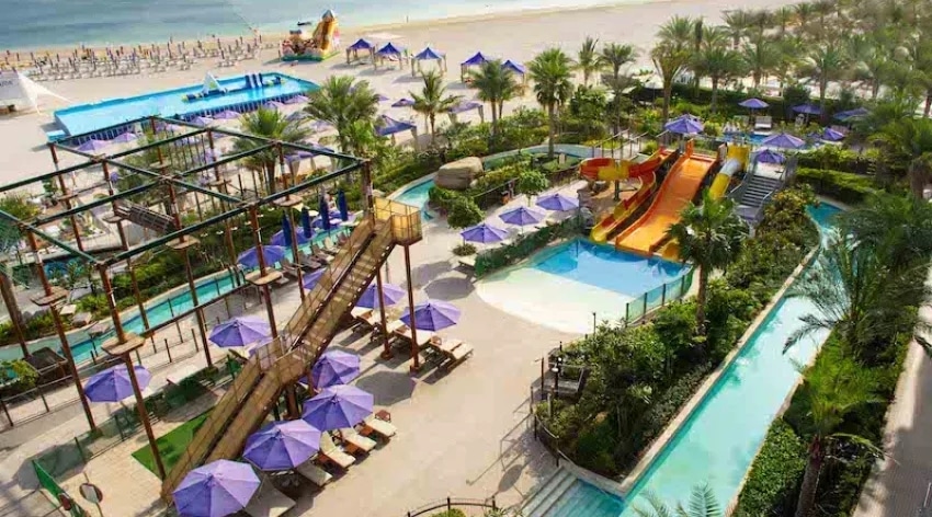 Vue aérienne du parc aquatique familial et de la plage privée d’un resort balnéaire