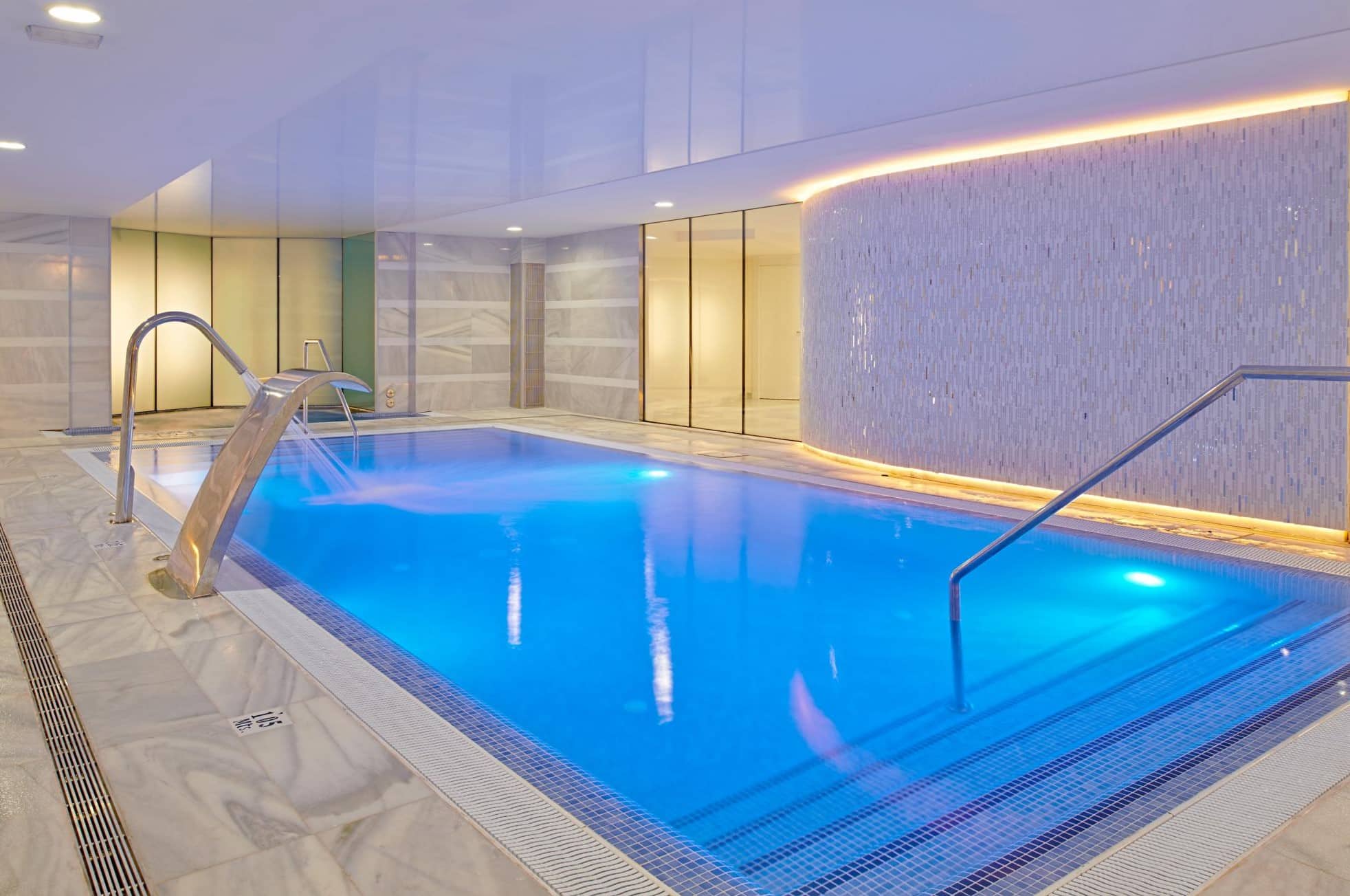 http://Piscine%20intérieure%20avec%20éclairage%20tamisé%20et%20jets%20massants%20dans%20un%20espace%20spa%20élégant