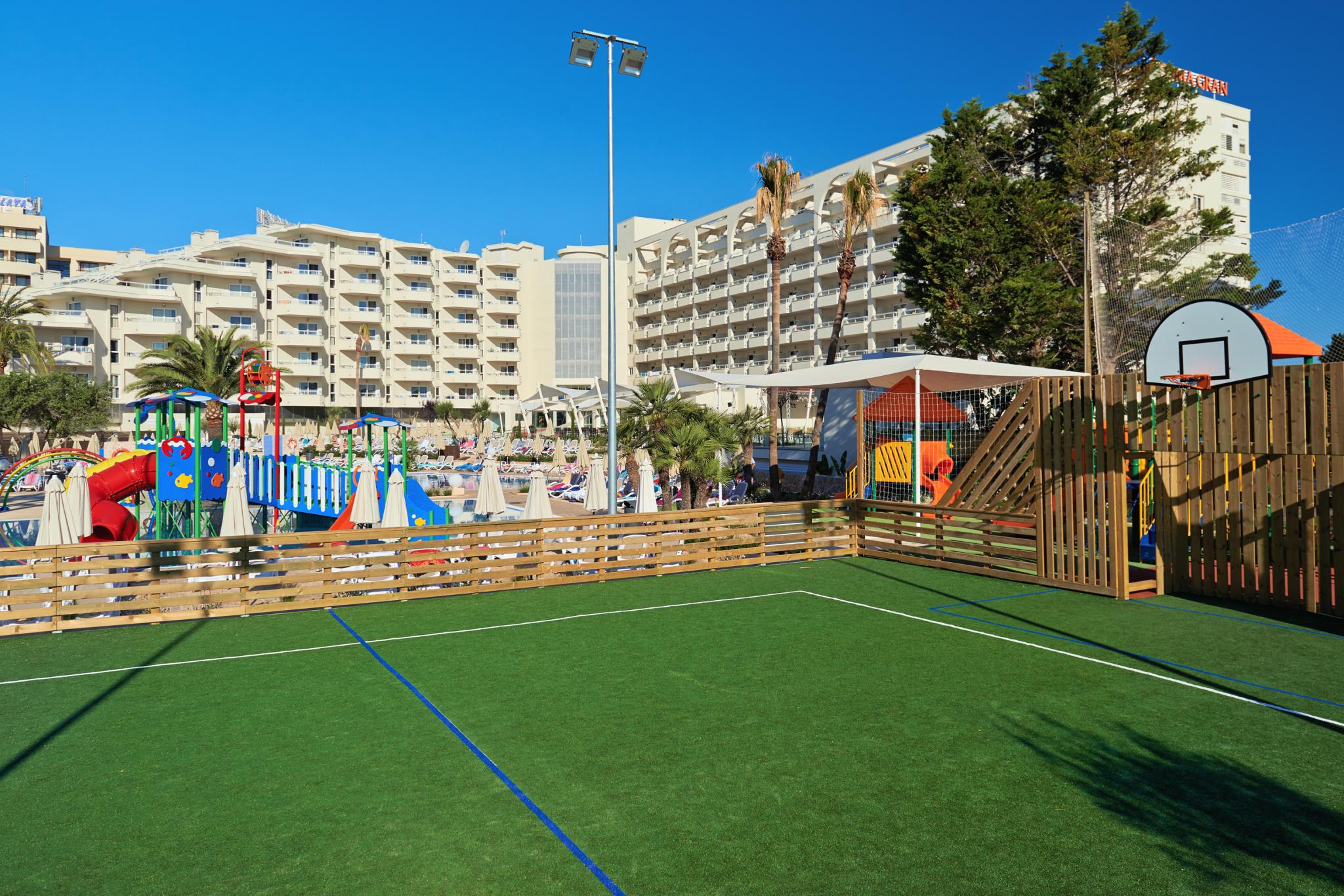 http://Terrain%20de%20sport%20avec%20panier%20de%20basket%20et%20aire%20de%20jeux%20colorée%20pour%20enfants%20dans%20un%20hôtel%20de%20vacances