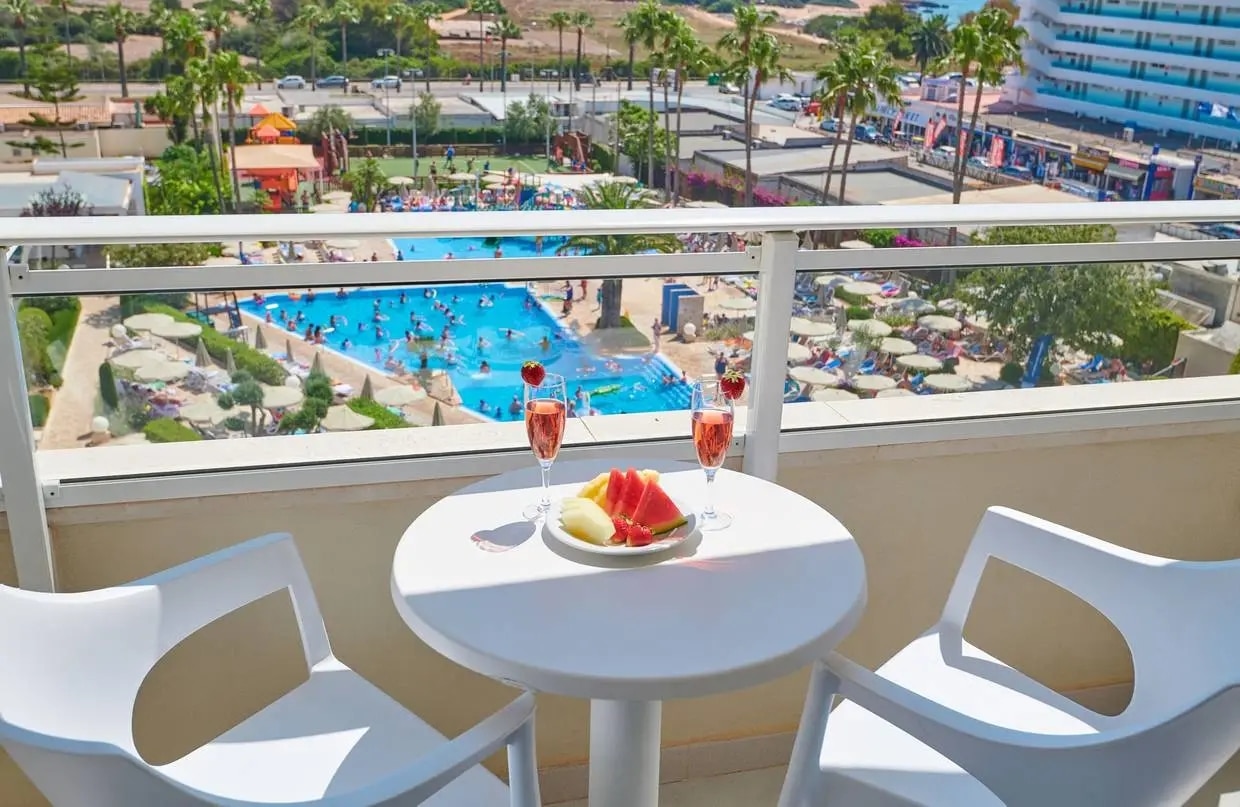 http://Plateau%20de%20fruits%20et%20verres%20de%20jus%20sur%20une%20table%20de%20balcon%20avec%20vue%20sur%20la%20piscine%20d’un%20complexe%20hôtelier