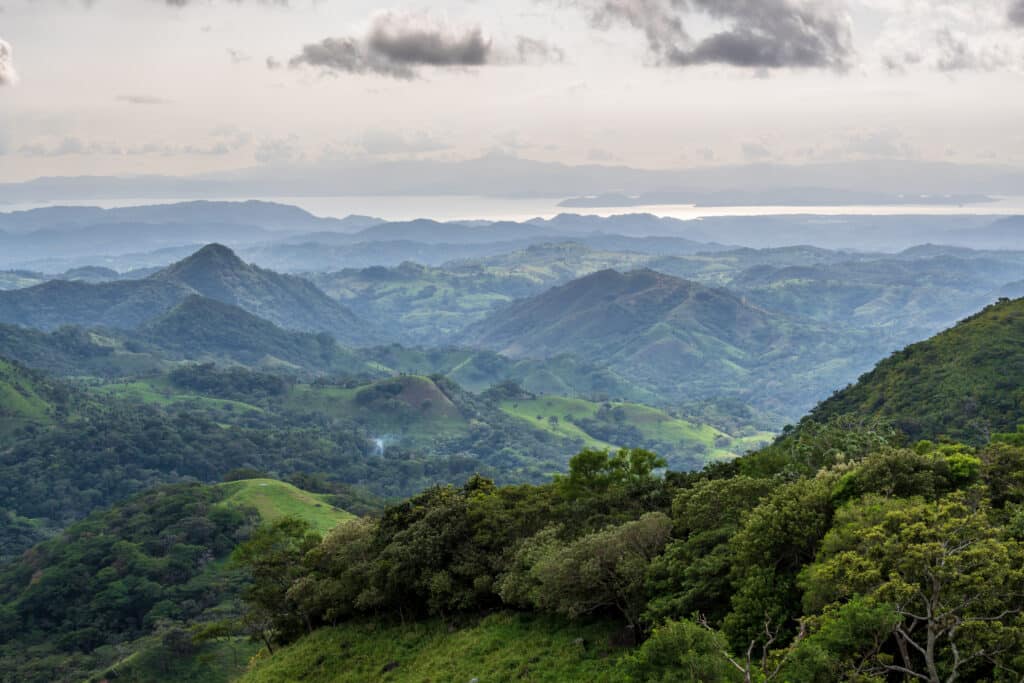 Panorama des montagnes verdoyantes du Costa Rica avec vue sur l’océan au loin