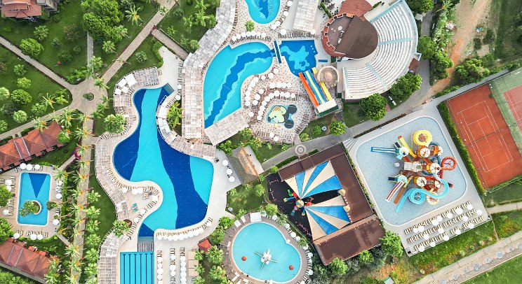 http://Vue%20aérienne%20d’un%20hôtel%20avec%20piscines,%20terrains%20de%20sport%20et%20espaces%20enfants.