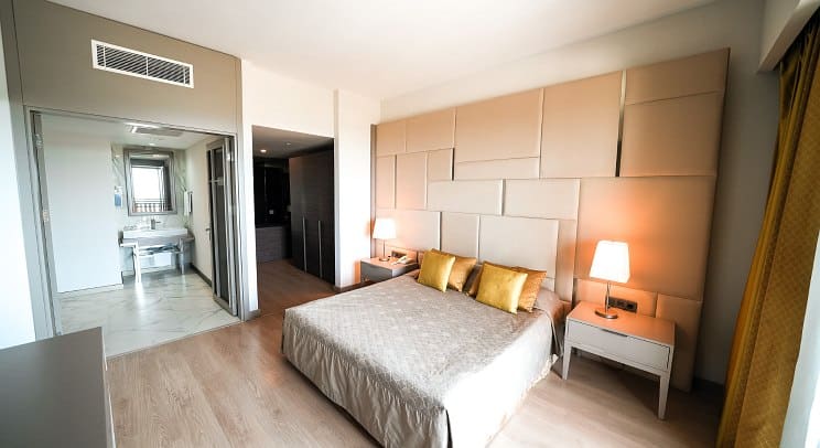 http://Chambre%20lumineuse%20avec%20lit%20double,%20lampes%20design%20et%20salle%20de%20bain%20ouverte.