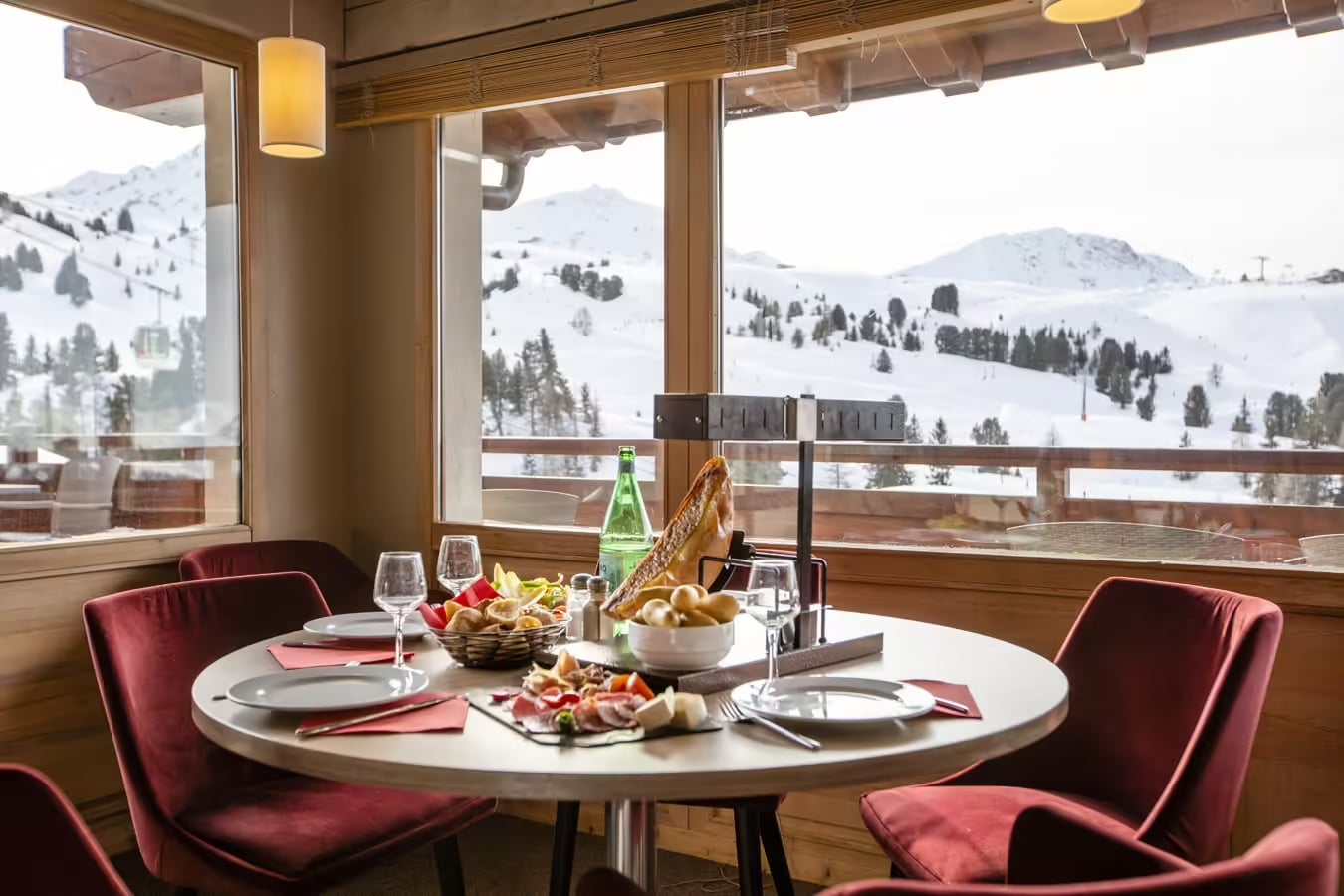 http://Table%20dressée%20pour%20une%20raclette%20avec%20vue%20panoramique%20sur%20les%20montagnes%20depuis%20un%20restaurant%20d’altitude