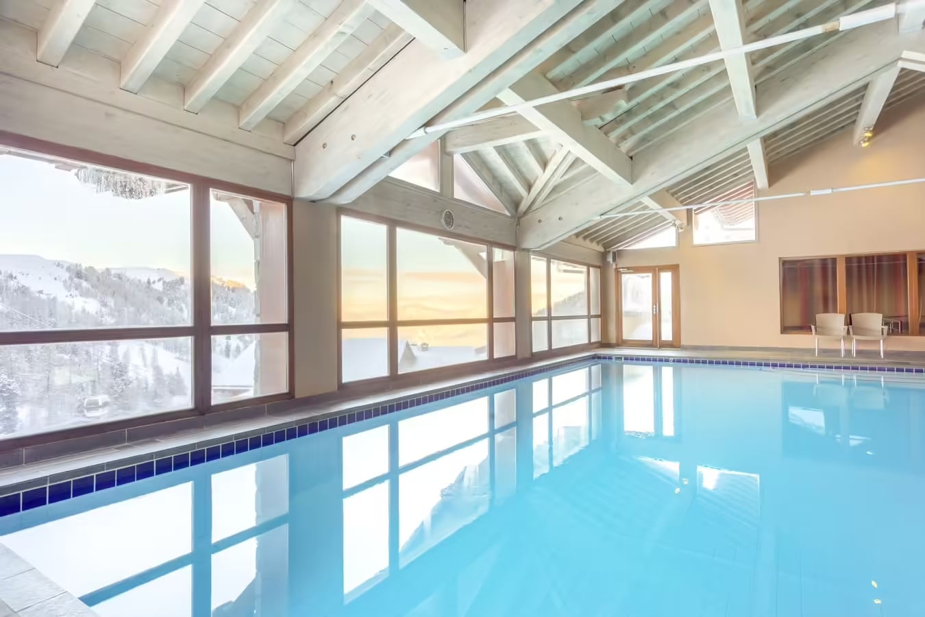 http://Piscine%20intérieure%20dans%20un%20hôtel%20de%20montagne%20avec%20baies%20vitrées%20sur%20la%20neige