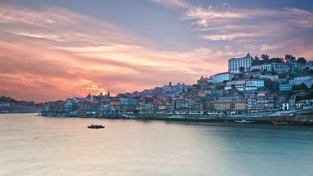 http://Vue%20panoramique%20de%20Porto,%20Portugal,%20avec%20la%20rivière%20Douro%20reflétant%20le%20coucher%20de%20soleil%20et%20des%20maisons%20colorées%20sur%20la%20colline.