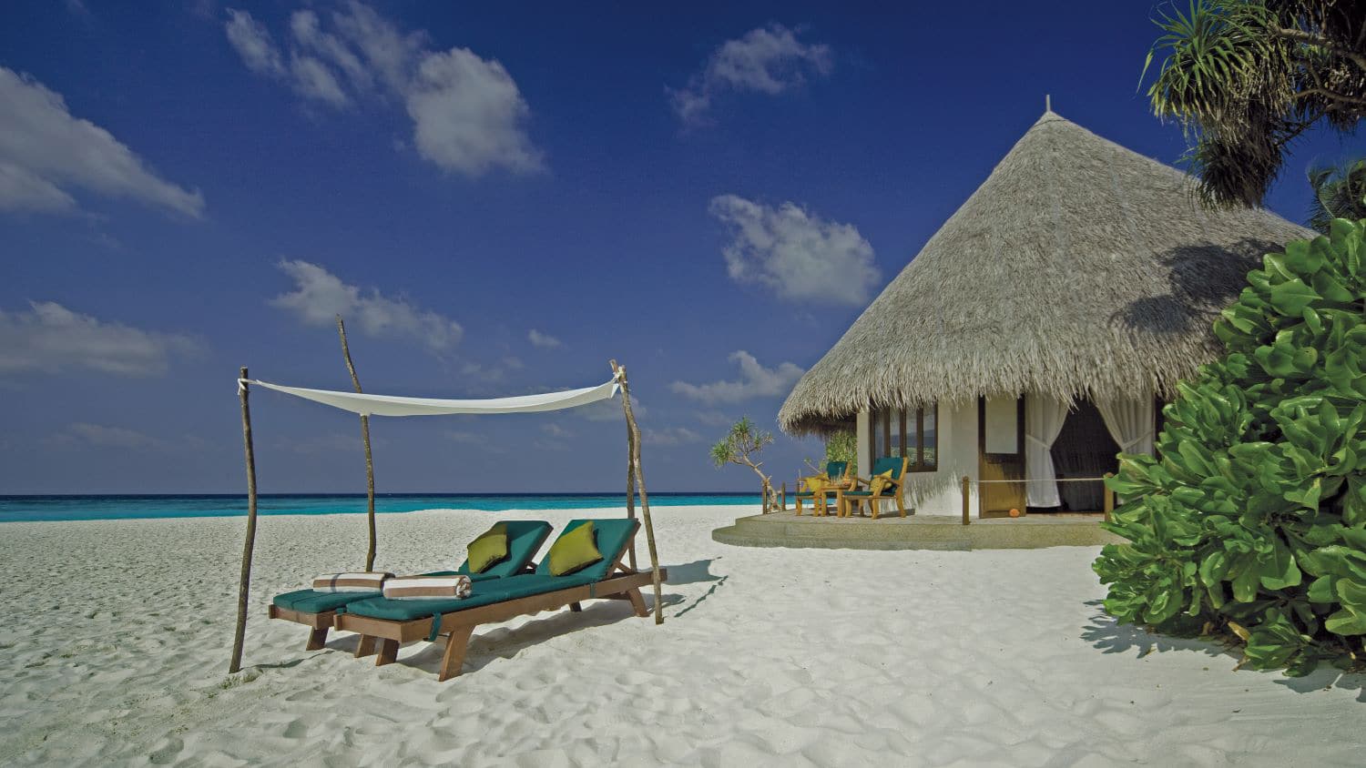 http://Bungalow%20en%20toit%20de%20chaume%20sur%20plage%20de%20sable%20blanc%20avec%20transats%20et%20parasol