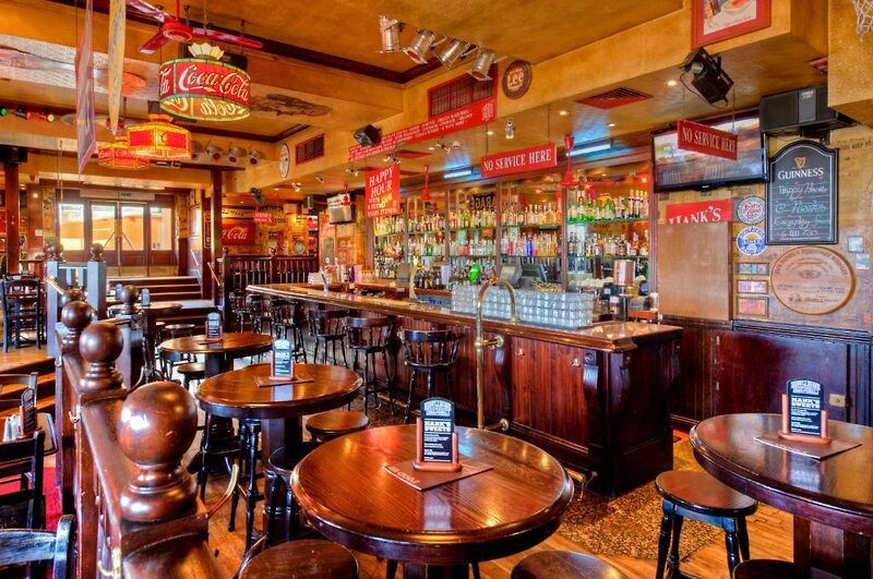 http://Intérieur%20d’un%20bar%20convivial%20avec%20tables%20en%20bois%20et%20large%20choix%20de%20boissons