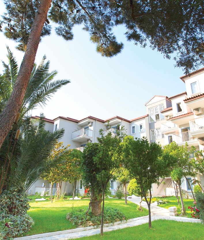 Façade d’un hôtel entourée de jardins verdoyants et palmiers
