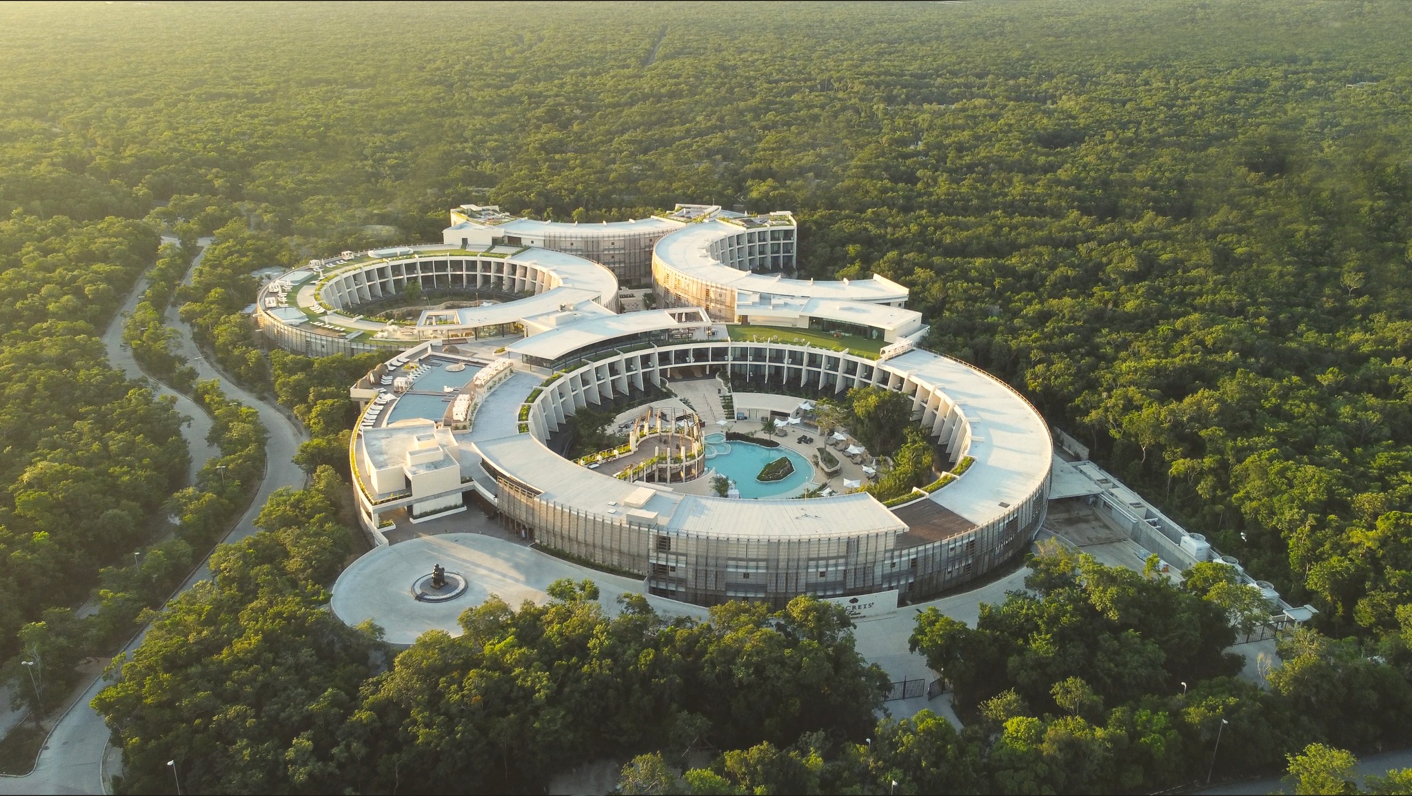 http://Vue%20aérienne%20d’un%20hôtel%20de%20luxe%20entouré%20de%20jungle,%20avec%20piscine%20centrale%20et%20architecture%20moderne
