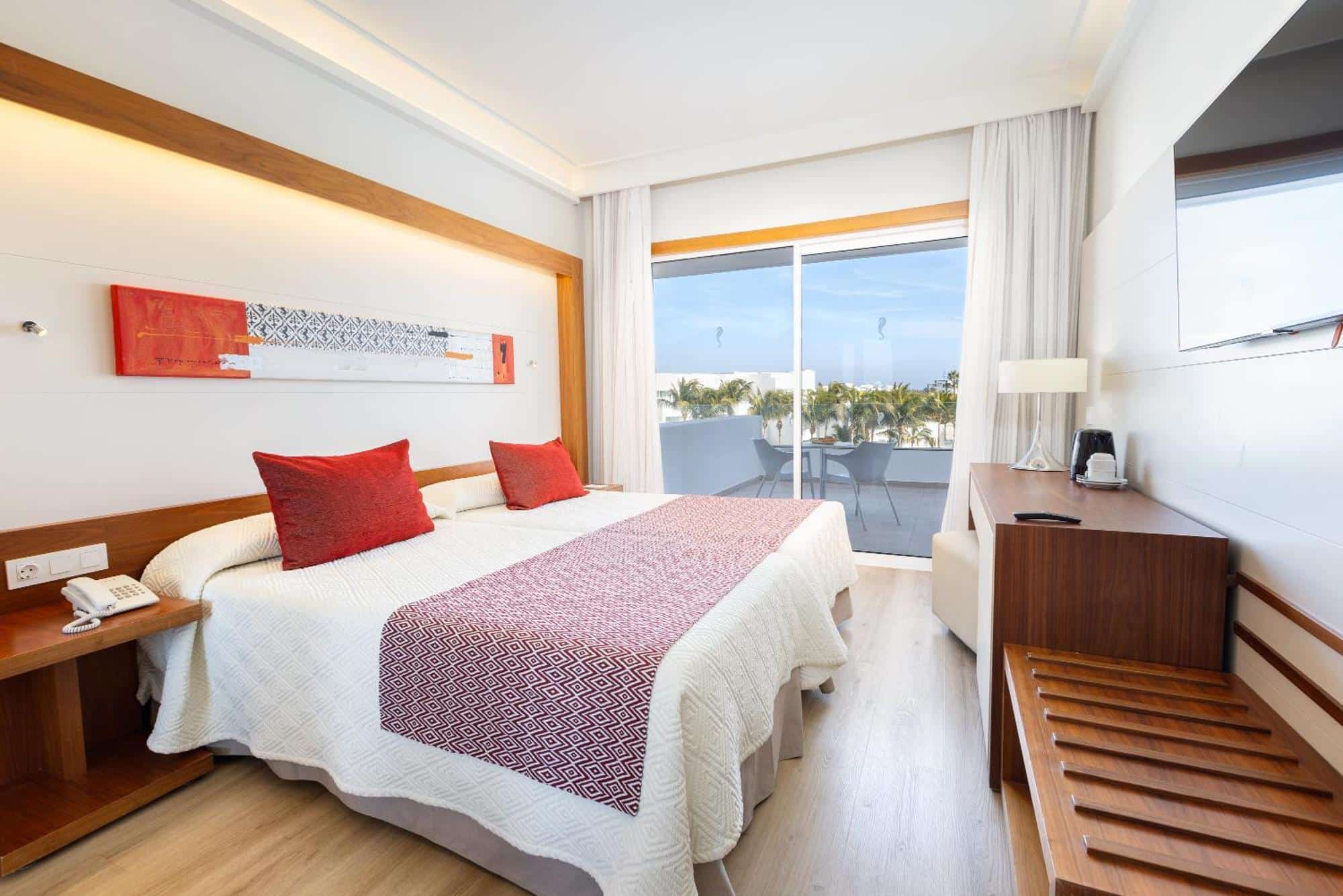 http://Chambre%20d’hôtel%20contemporaine%20avec%20balcon%20privé%20et%20vue%20sur%20les%20palmiers%20et%20la%20mer