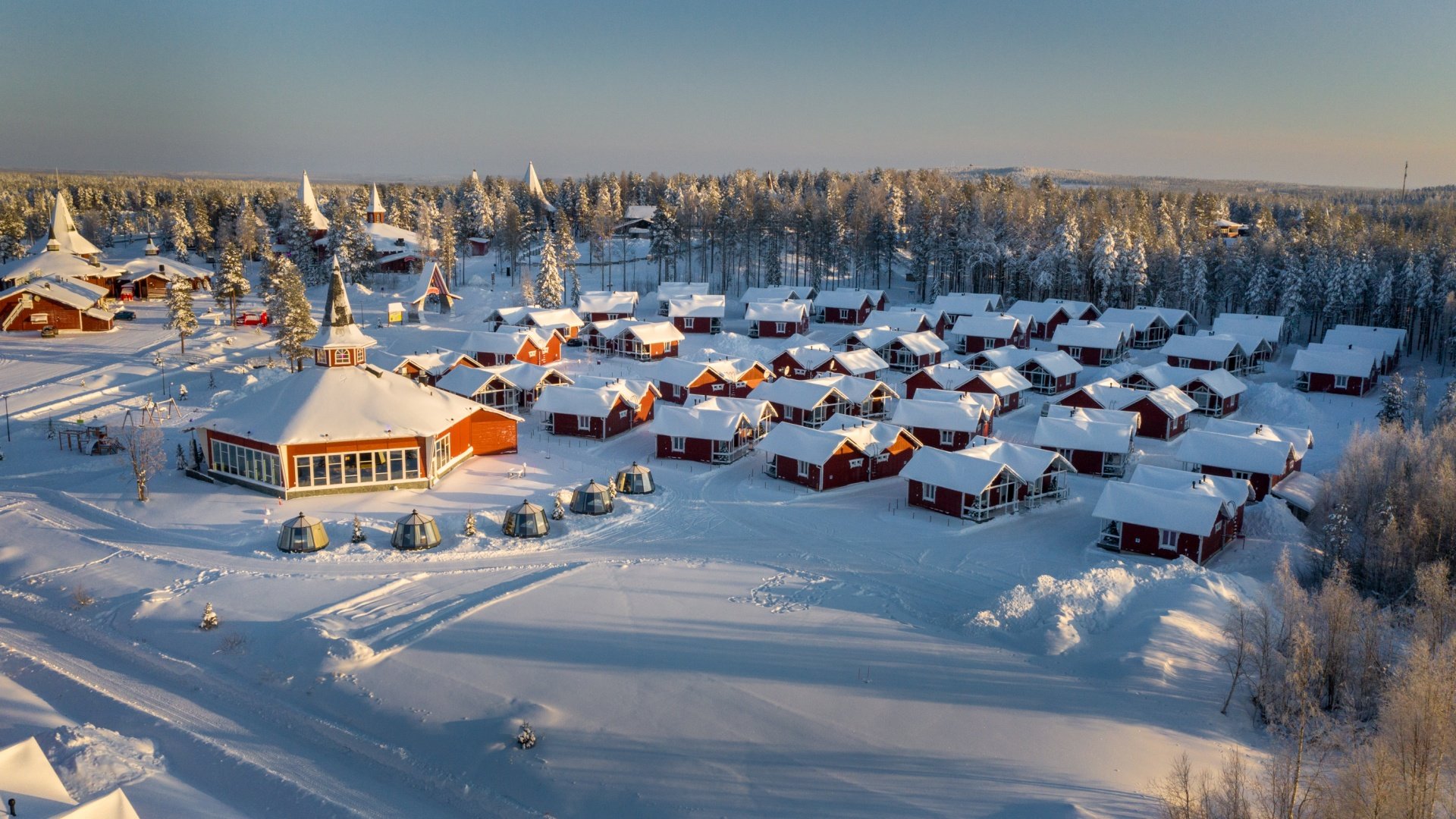 http://Vue%20aérienne%20d’un%20village%20de%20chalets%20rouges%20sous%20la%20neige%20en%20Laponie%20finlandaise