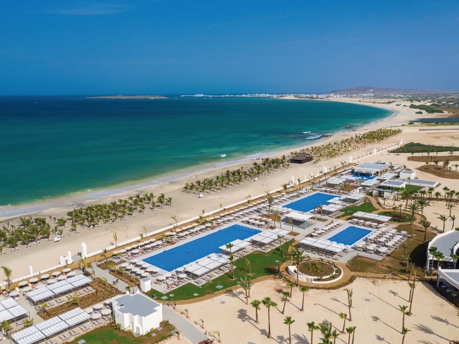 http://Vue%20aérienne%20d'un%20hôtel%20au%20Cap-Vert,%20avec%20plusieurs%20piscines%20et%20une%20plage%20de%20sable%20fin%20bordant%20l'océan.
