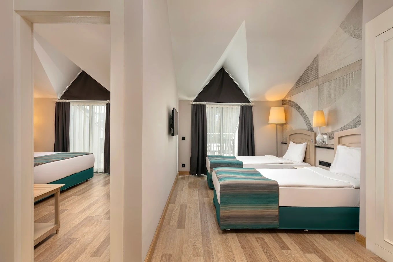 http://Chambre%20d’hôtel%20familiale%20moderne%20avec%20deux%20lits%20simples%20et%20un%20lit%20double%20séparés.