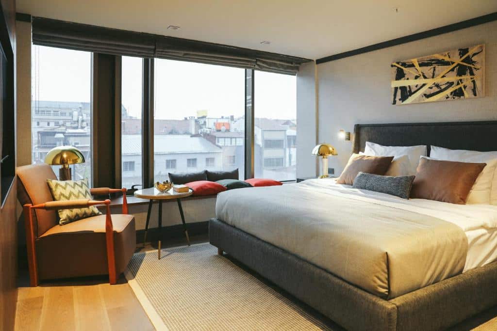 http://Chambre%20spacieuse%20d’un%20hôtel%20d’Istanbul%20avec%20grand%20lit,%20coin%20lecture%20et%20vue%20sur%20les%20toits%20de%20la%20ville.