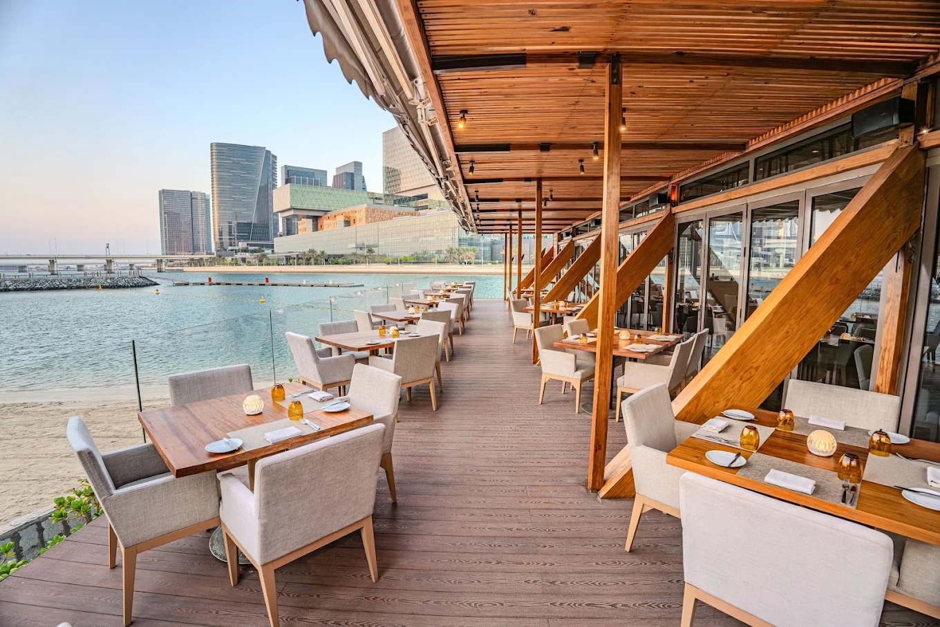http://Terrasse%20de%20restaurant%20en%20bord%20de%20mer%20avec%20vue%20sur%20les%20gratte-ciel%20d'une%20ville%20moderne