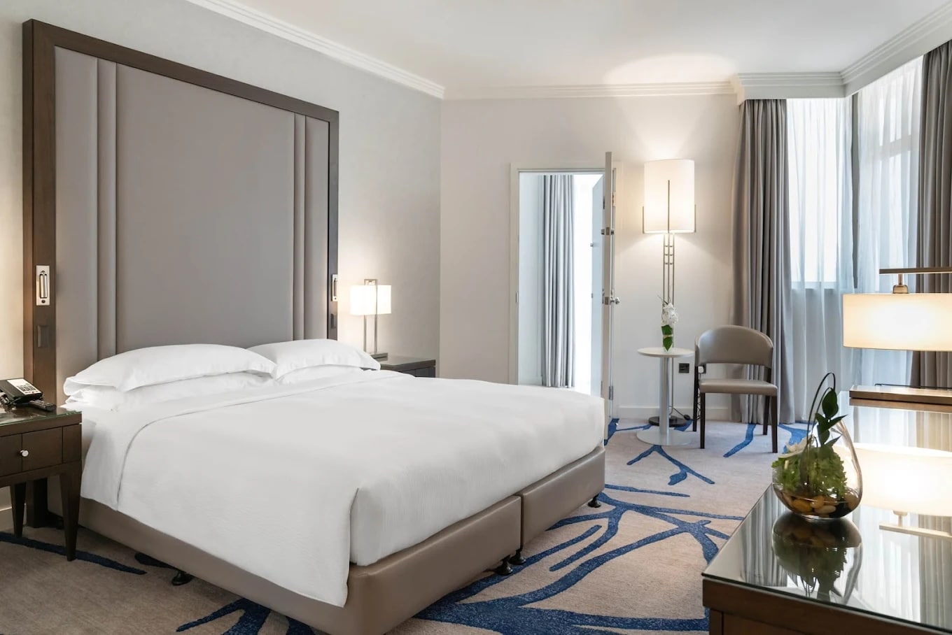 http://Chambre%20d’hôtel%20spacieuse%20avec%20grande%20fenêtre,%20lit%20double%20et%20éclairage%20tamisé