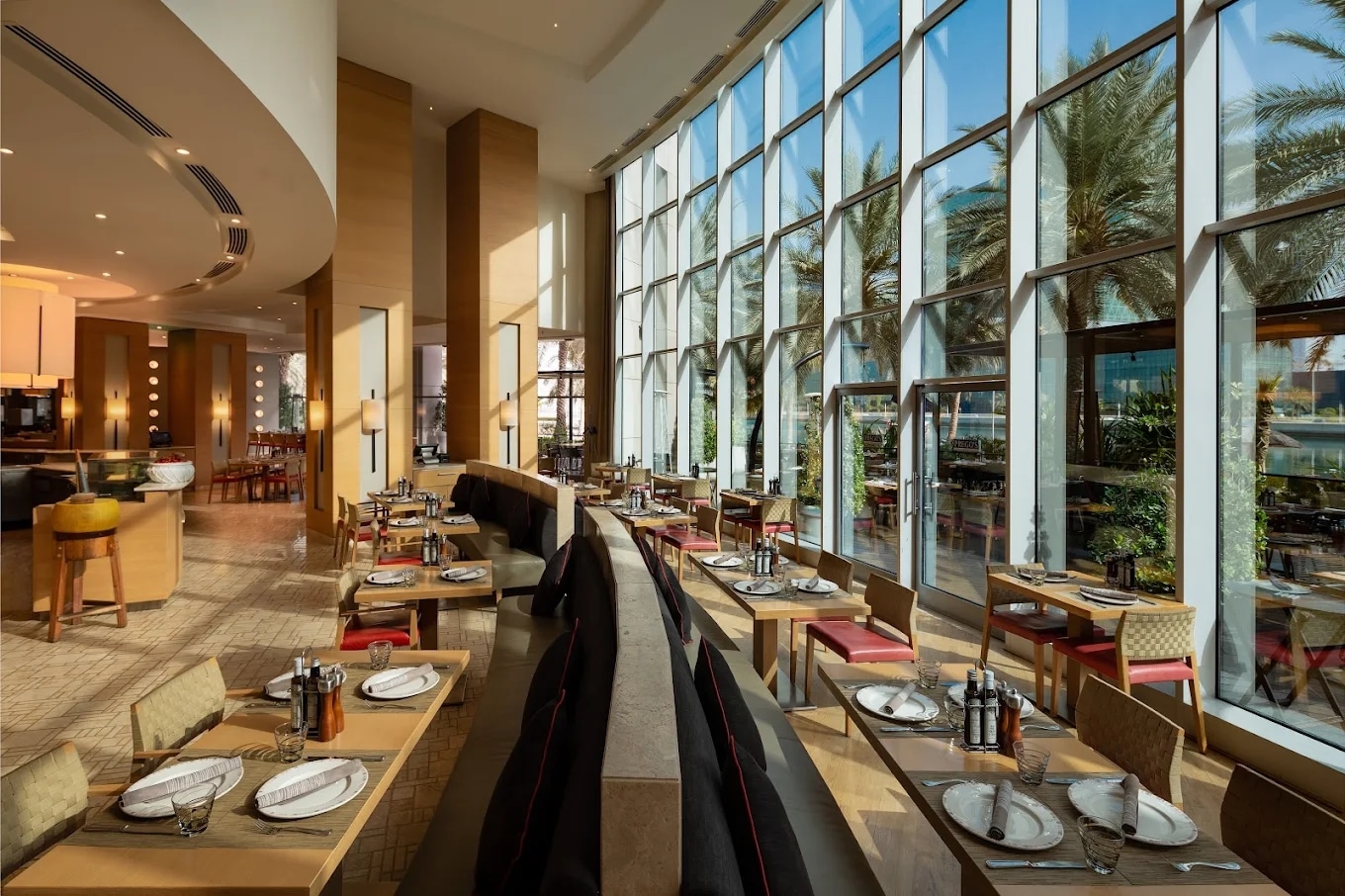 http://Salle%20de%20restaurant%20moderne%20avec%20tables%20élégantes%20et%20vue%20extérieure%20sur%20palmiers