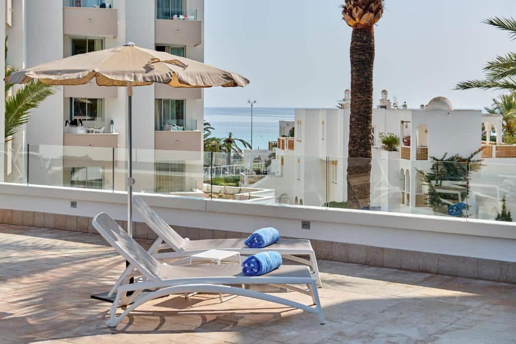 http://Transats%20avec%20serviettes%20bleues%20sur%20la%20terrasse%20d’un%20hôtel%20donnant%20sur%20la%20mer%20Méditerranée
