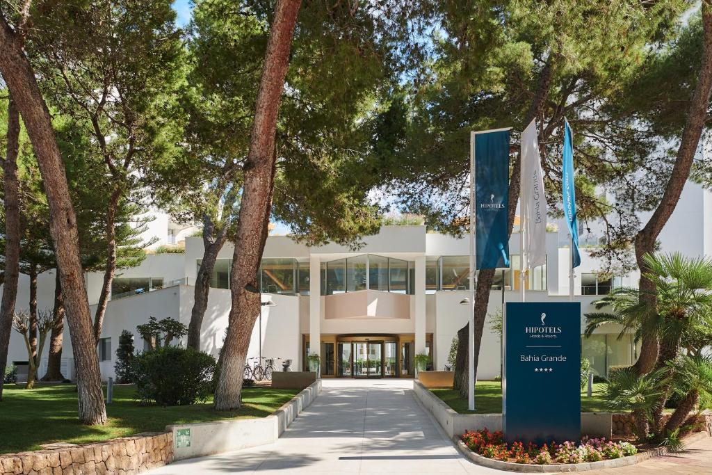 http://Entrée%20de%20l’hôtel%20Hipotels%20Bahia%20Grande%20entourée%20de%20pins%20et%20palmiers%20avec%20enseigne%204%20étoiles