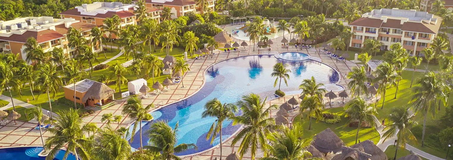 http://Vue%20aérienne%20d’un%20complexe%20hôtelier%20avec%20piscine,%20palmiers%20et%20jardins%20luxuriants.