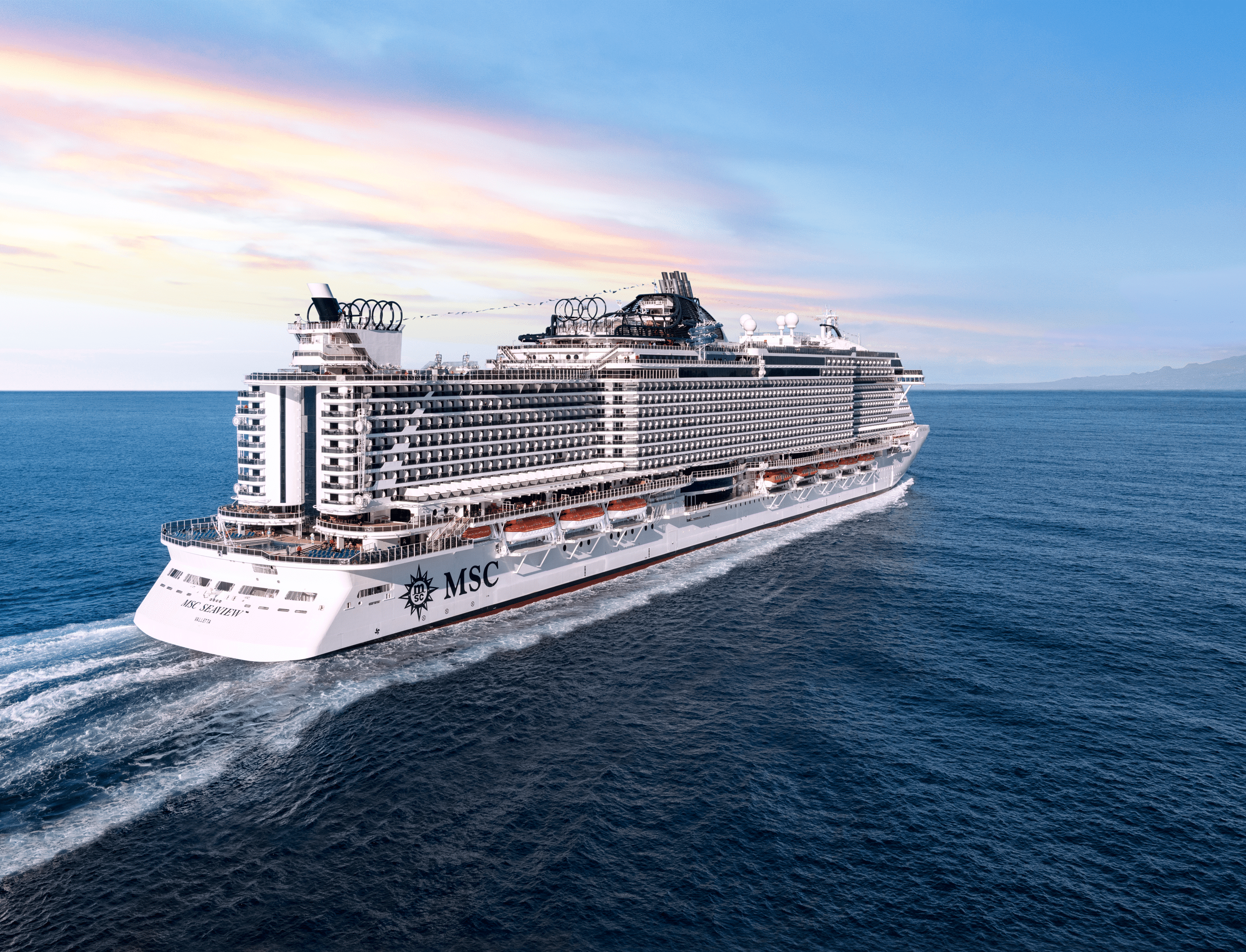 http://Vue%20arrière%20du%20navire%20de%20croisière%20MSC%20Seaview%20naviguant%20sur%20une%20mer%20calme%20au%20coucher%20du%20soleil.