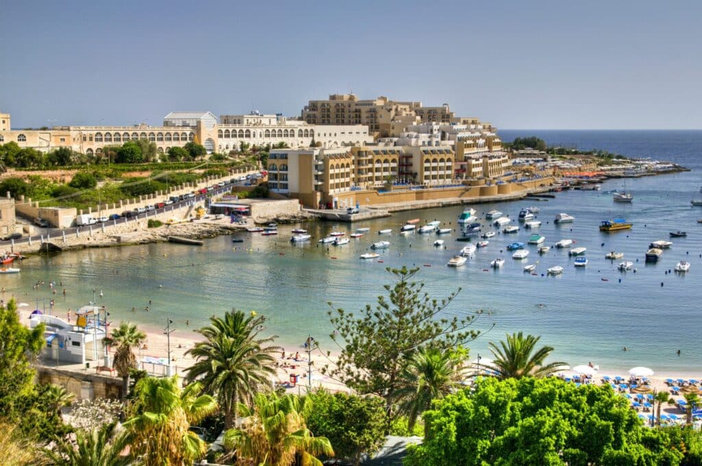 Panorama de la baie de Saint George à Malte avec hôtels, plage et bateaux amarrés