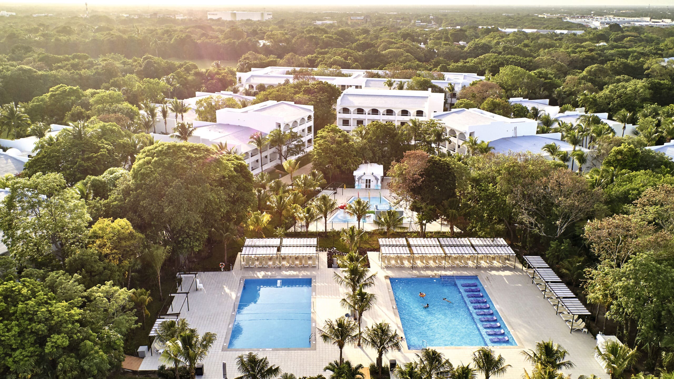 http://Vue%20aérienne%20d’un%20resort%20avec%20piscines%20et%20bâtiments%20entourés%20de%20végétation%20luxuriante