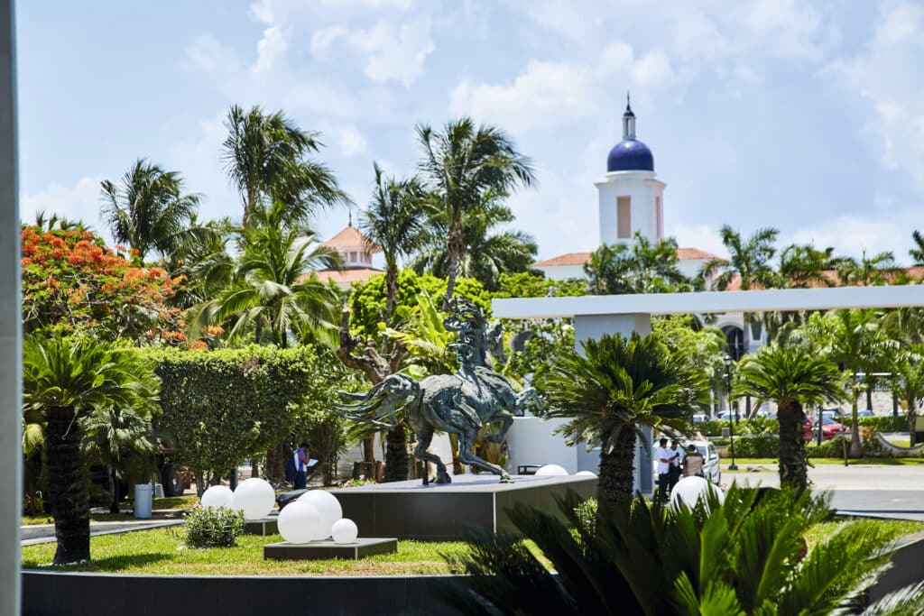 Jardin d’hôtel avec sculpture de cheval et végétation tropicale à l’entrée d’un resort