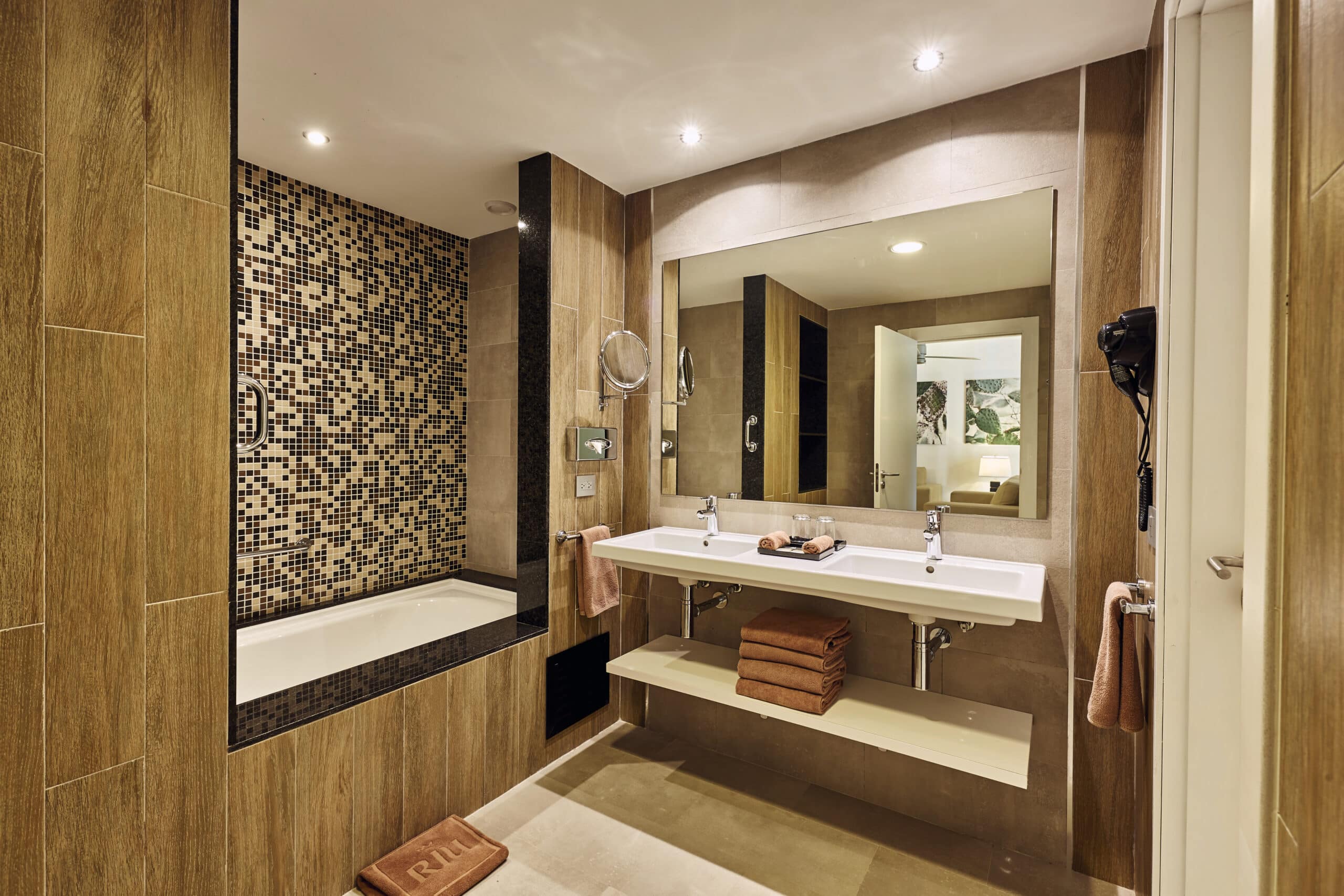 http://Salle%20de%20bain%20moderne%20d’un%20hôtel%20avec%20grande%20douche,%20double%20vasque%20et%20finitions%20bois