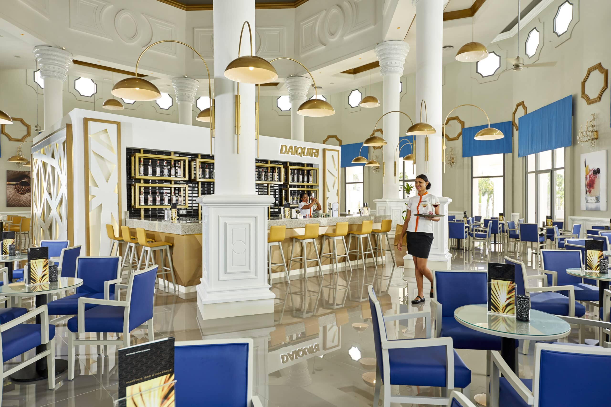 http://Bar%20à%20cocktails%20élégant%20avec%20chaises%20hautes%20et%20décoration%20dorée%20dans%20un%20lounge%20d’hôtel.