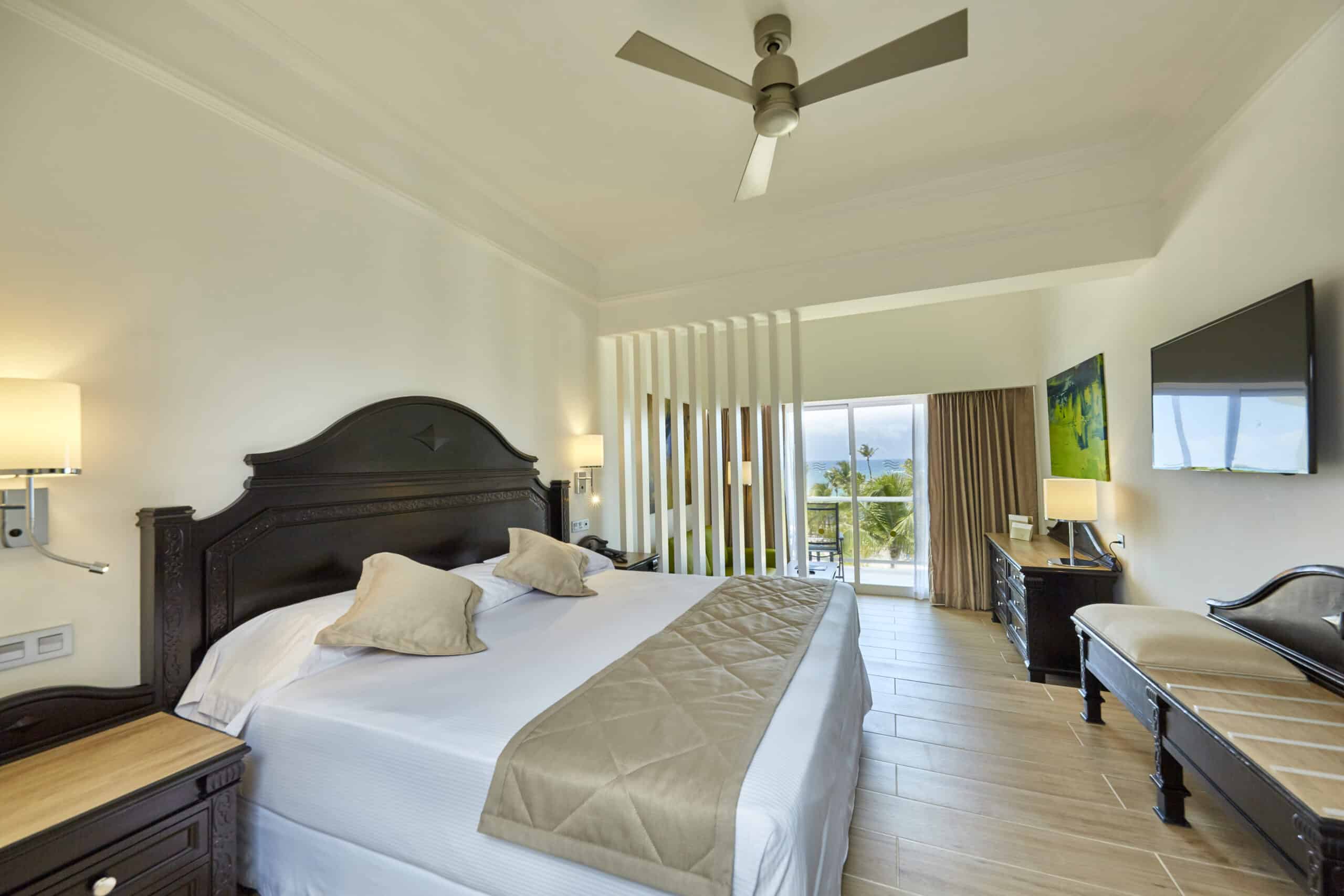 http://Chambre%20lumineuse%20avec%20lit%20double,%20meubles%20en%20bois%20foncé%20et%20balcon%20avec%20vue%20sur%20la%20mer.