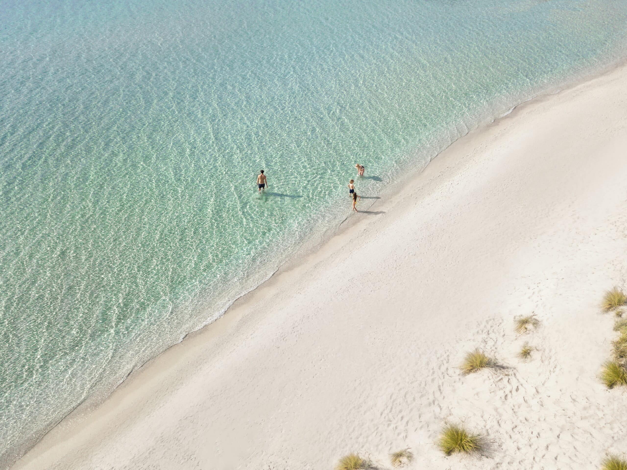 http://Plage%20de%20sable%20blanc%20et%20eaux%20cristallines%20à%20l’Ikos%20Olivia,%20idéal%20pour%20une%20baignade%20relaxante.