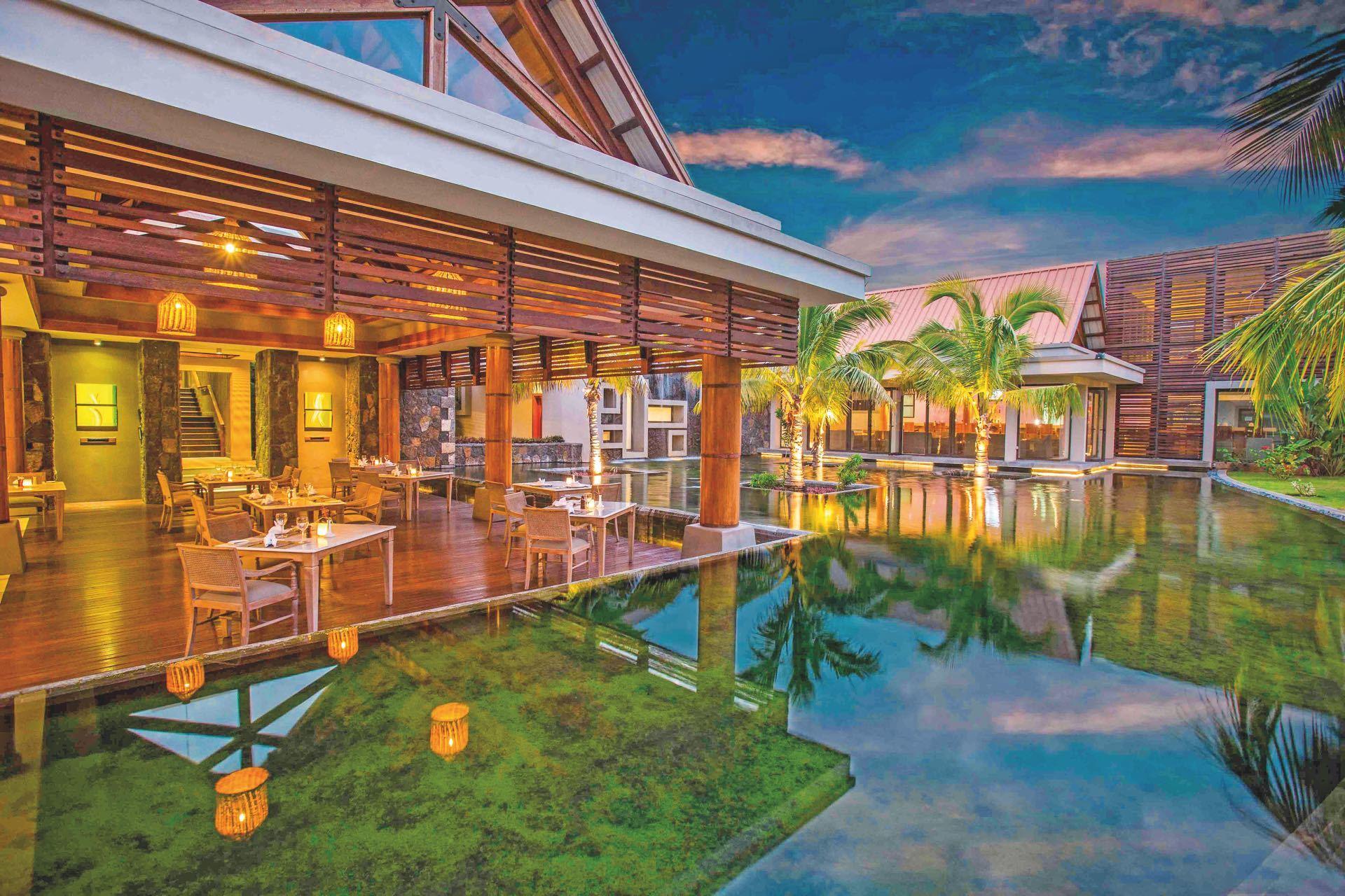 http://Restaurant%20en%20terrasse%20sur%20pilotis%20avec%20éclairage%20chaleureux%20et%20végétation%20luxuriante
