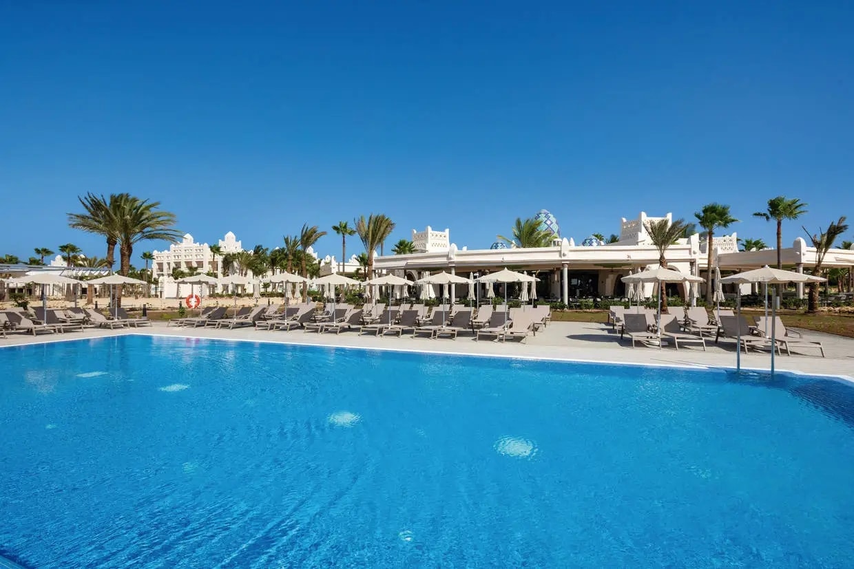 http://Grande%20piscine%20d'un%20hôtel%205%20étoiles%20au%20Cap-Vert,%20avec%20transats%20et%20parasols%20sous%20un%20ciel%20bleu.