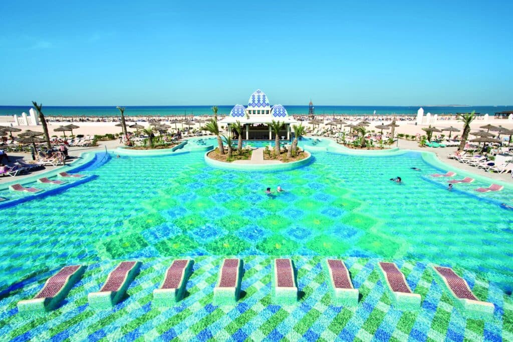 Piscine à débordement avec vue sur la plage dans un complexe hôtelier de luxe au Cap-Vert.