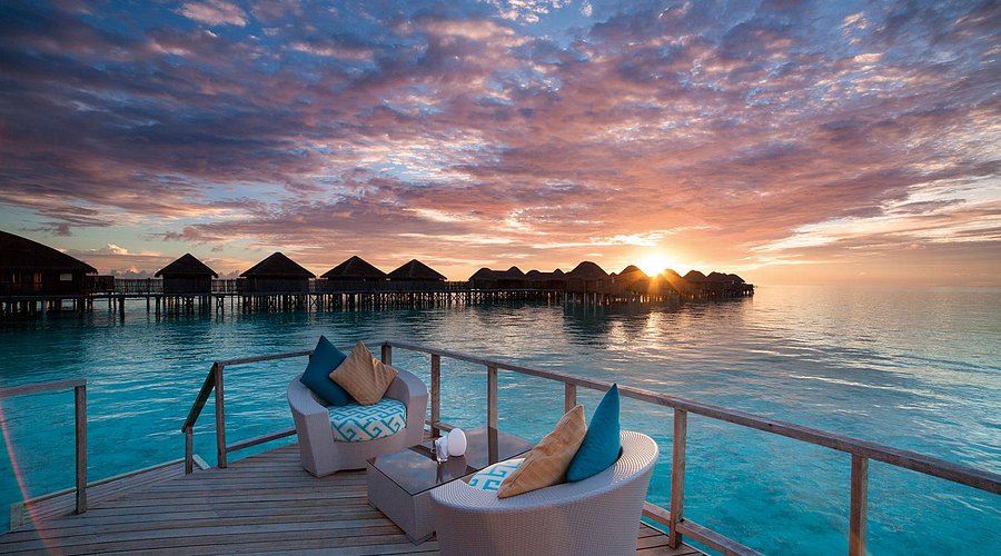 http://Terrasse%20en%20bois%20sur%20pilotis%20avec%20fauteuils%20face%20au%20coucher%20de%20soleil%20sur%20l’océan%20Indien