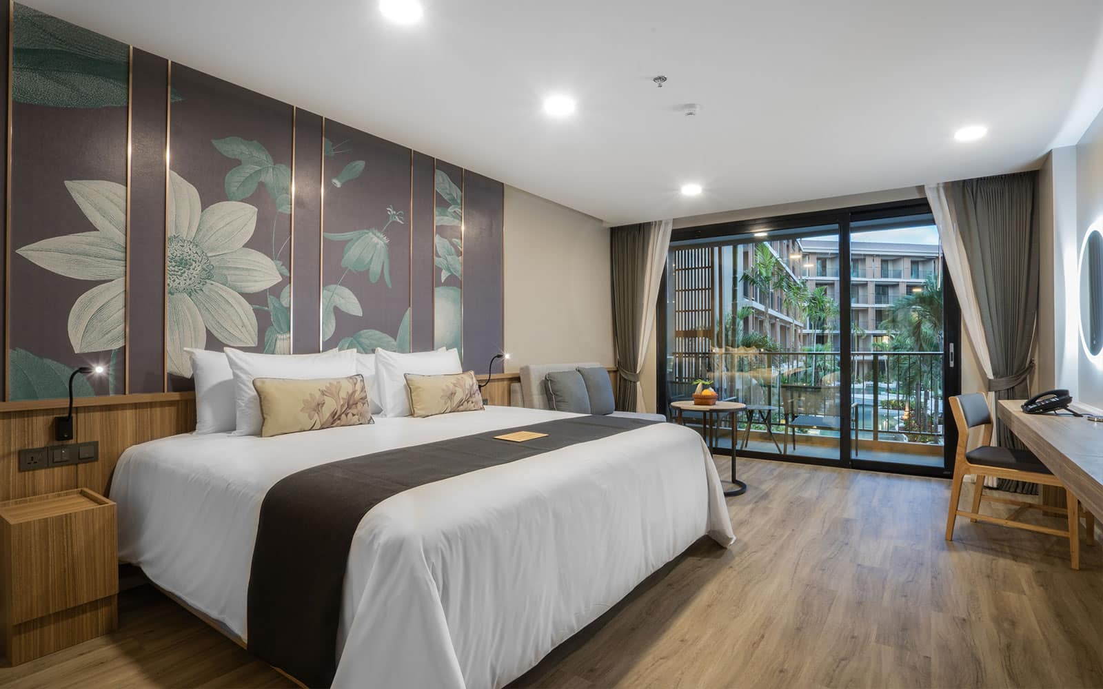http://Chambre%20d’hôtel%20moderne%20avec%20grand%20lit,%20décor%20floral%20et%20balcon%20sur%20piscine