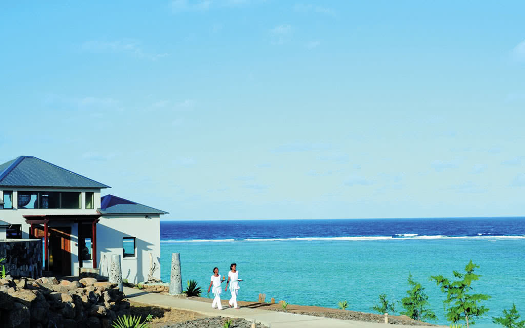 http://Promenade%20côtière%20avec%20deux%20femmes%20marchant%20face%20à%20l’océan%20à%20l’île%20Maurice.