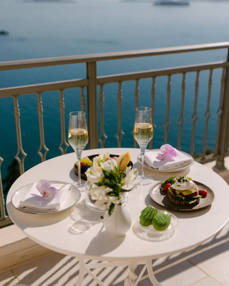 http://Table%20dressée%20avec%20coupes%20de%20champagne,%20fruits%20et%20viennoiseries%20sur%20balcon%20avec%20vue%20sur%20la%20mer